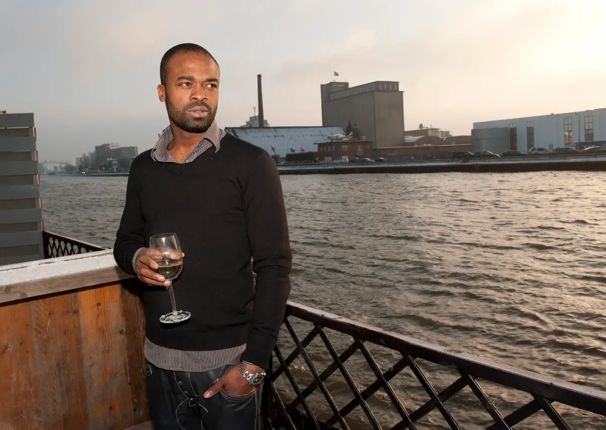 portret van kok op het terras van zijn restaurant met ene glas wijn in zijn hand